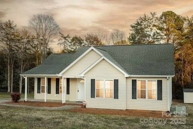 view of front of property featuring covered porch and a lawn