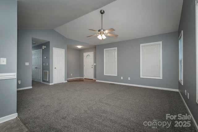 spare room featuring dark carpet, ceiling fan, and vaulted ceiling