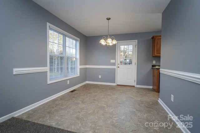 unfurnished dining area with an inviting chandelier and a wealth of natural light