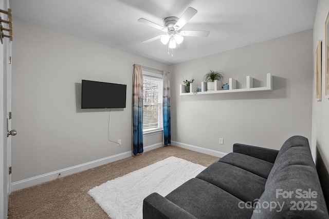 carpeted living area with a ceiling fan and baseboards