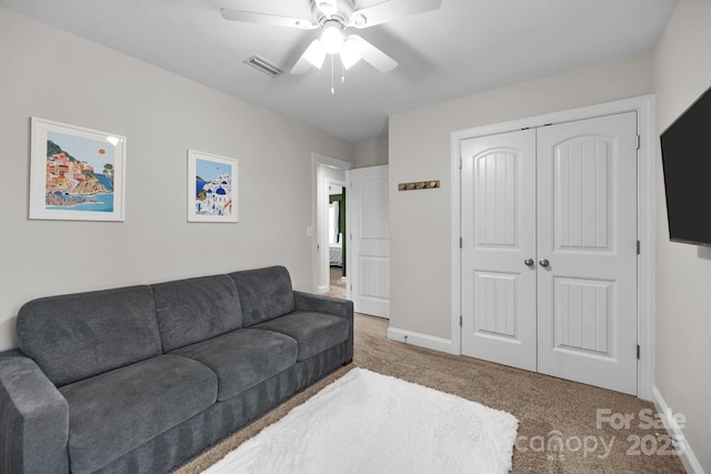 carpeted living area featuring visible vents, ceiling fan, and baseboards