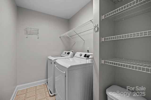 laundry area featuring laundry area, independent washer and dryer, light floors, and baseboards