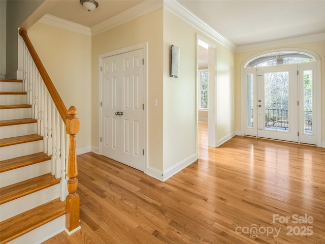 entryway with ornamental molding and light wood-type flooring