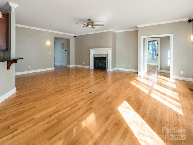 unfurnished living room with light wood-type flooring, ornamental molding, and ceiling fan