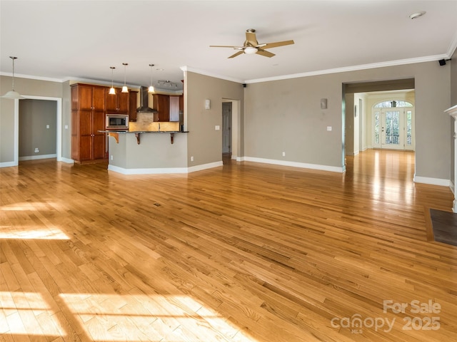 unfurnished living room featuring ceiling fan, light wood-type flooring, and crown molding