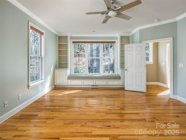 unfurnished room featuring ceiling fan, ornamental molding, light wood-type flooring, and plenty of natural light