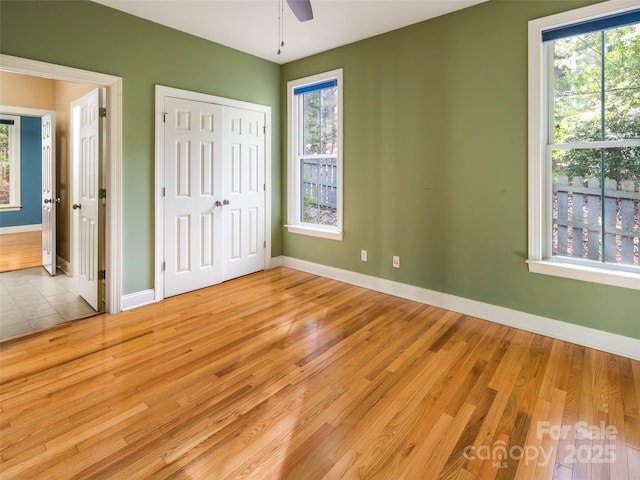 unfurnished bedroom with ceiling fan, light hardwood / wood-style flooring, a closet, and ensuite bathroom