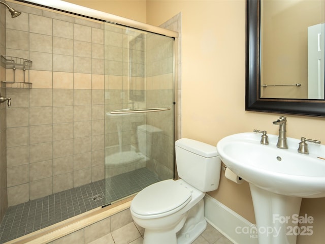 bathroom with tile patterned floors, toilet, and an enclosed shower