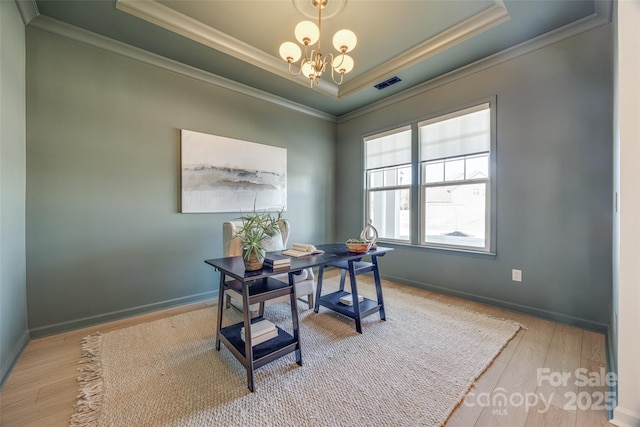 office area with ornamental molding, a tray ceiling, a notable chandelier, and wood finished floors