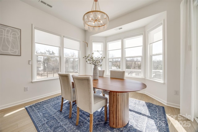 dining space with visible vents, baseboards, and wood finished floors