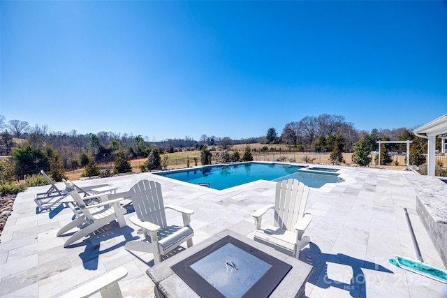 view of pool with a pool with connected hot tub, a patio area, and fence