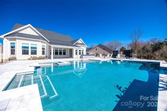 view of pool featuring a pool with connected hot tub and a patio area