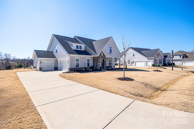 view of front of home featuring a front yard, stone siding, driveway, and a residential view