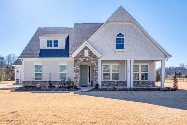 view of front of house with stone siding and a shingled roof