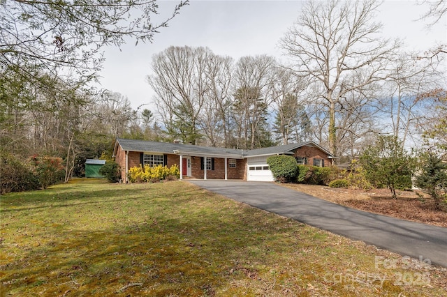 single story home featuring driveway, a front lawn, an attached garage, and brick siding