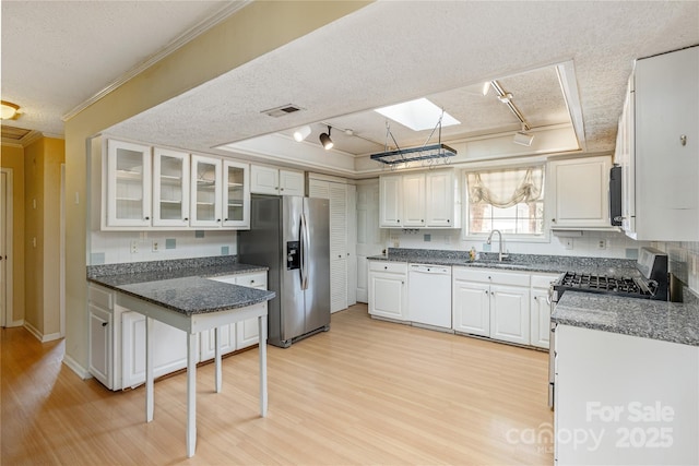 kitchen featuring a textured ceiling, stainless steel appliances, ornamental molding, and a skylight