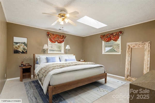 bedroom featuring a skylight, multiple windows, and a textured ceiling