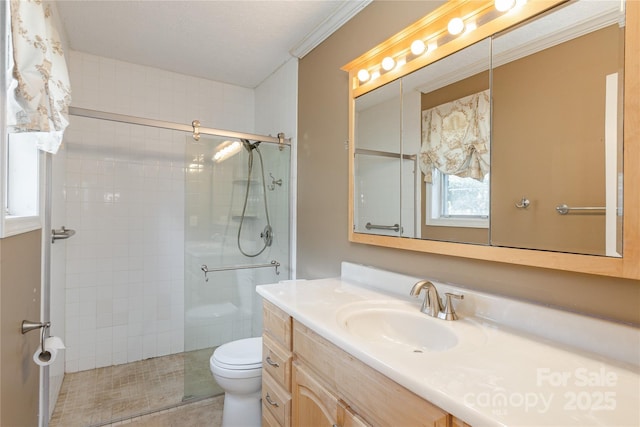 full bathroom with toilet, vanity, a tile shower, tile patterned floors, and crown molding