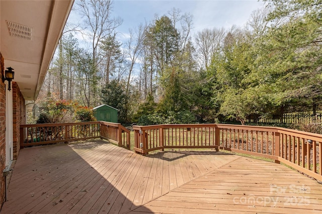 deck featuring an outbuilding, visible vents, and a shed