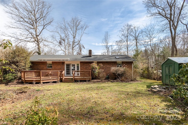 back of property featuring a storage shed, a wooden deck, an outbuilding, a yard, and brick siding