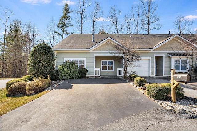 view of front of property with driveway and a shingled roof