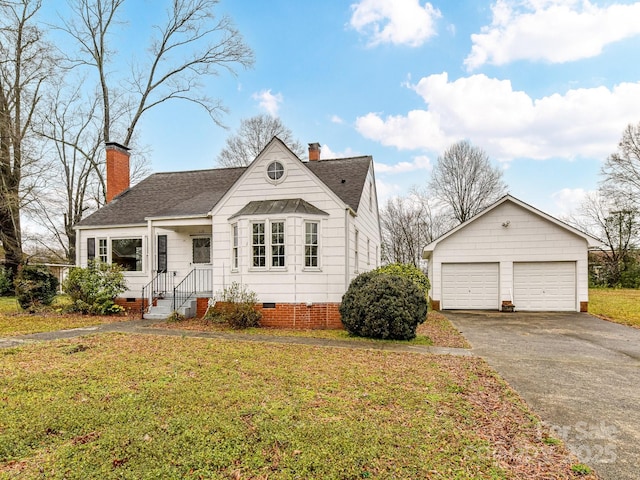 view of front of property featuring a garage, an outbuilding, and a front lawn