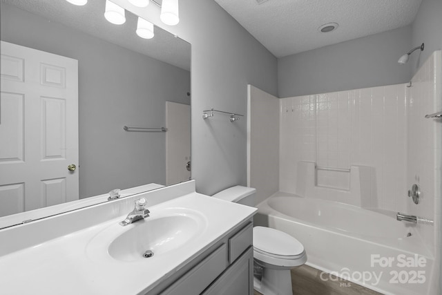 full bathroom with shower / bath combination, toilet, wood finished floors, a textured ceiling, and vanity