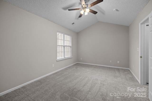 carpeted spare room with visible vents, baseboards, a ceiling fan, lofted ceiling, and a textured ceiling