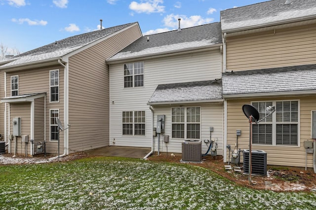 back of property with central AC, a yard, a patio, and a shingled roof