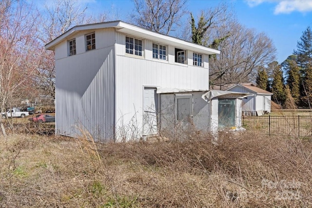 view of outbuilding featuring fence