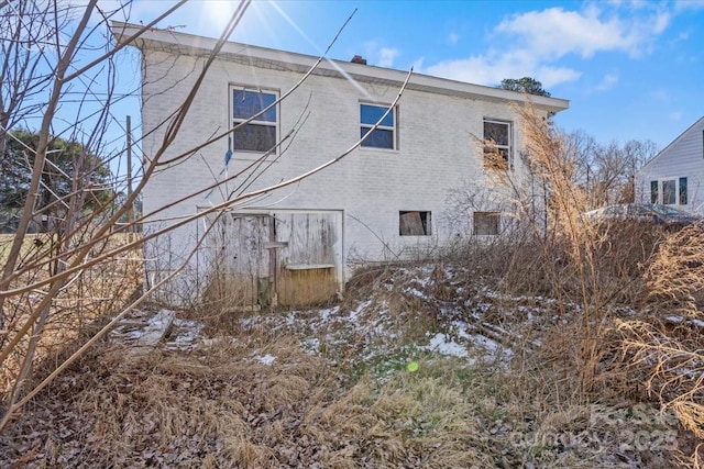 rear view of property with brick siding