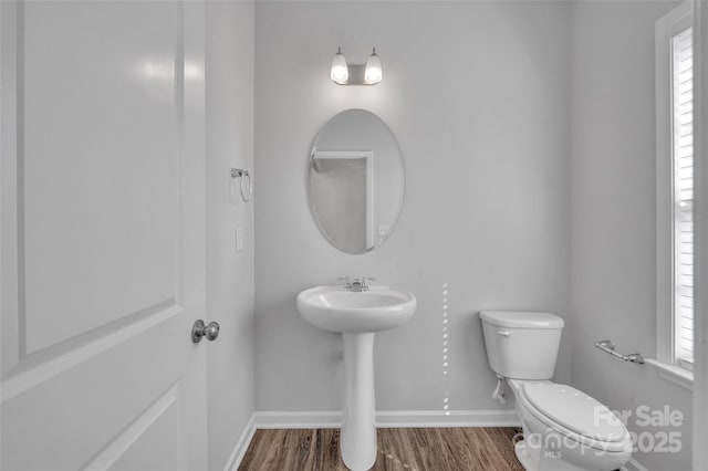 bathroom featuring hardwood / wood-style flooring and toilet