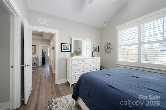 bedroom with ceiling fan, vaulted ceiling, and dark hardwood / wood-style flooring