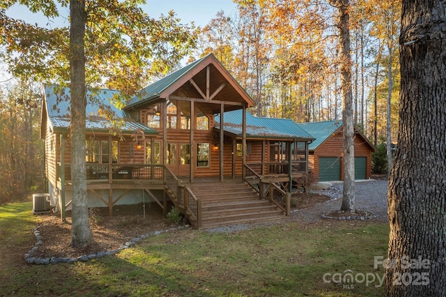 view of front of house featuring a front lawn, cooling unit, and a garage