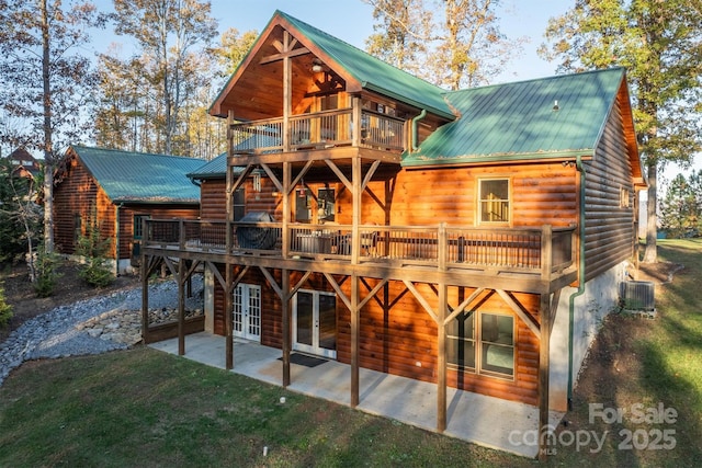 rear view of property with french doors, a lawn, a patio area, central AC unit, and a balcony