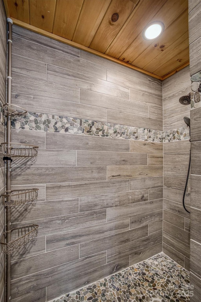 bathroom with a tile shower and wooden ceiling