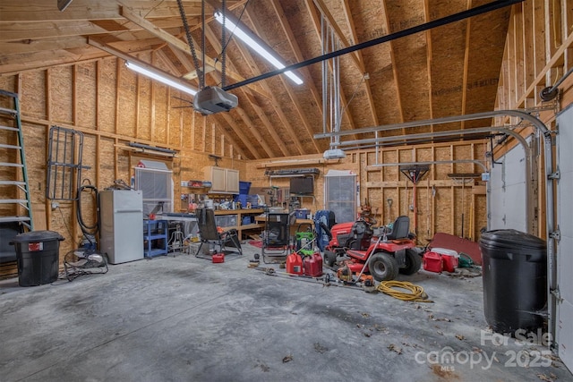 garage featuring a workshop area, white refrigerator, and a garage door opener