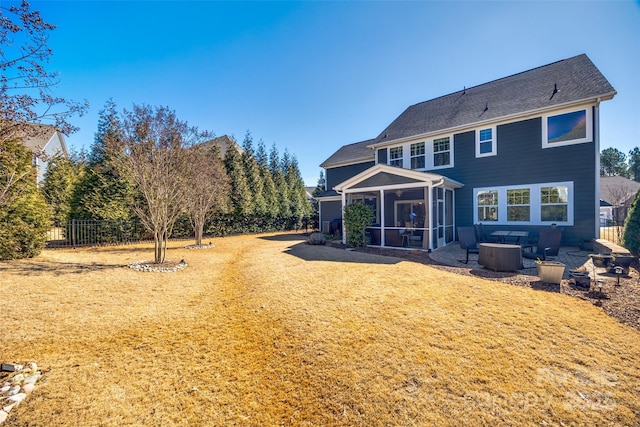 rear view of house with fence and a sunroom