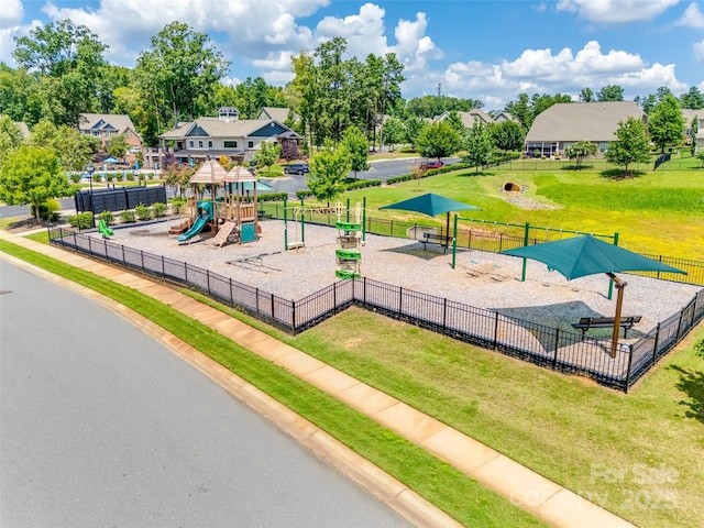 community jungle gym featuring a yard and fence