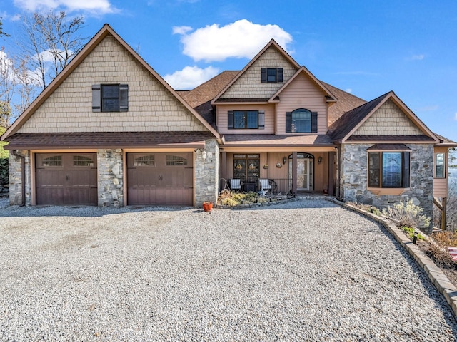 craftsman-style home with a garage, stone siding, driveway, and a shingled roof