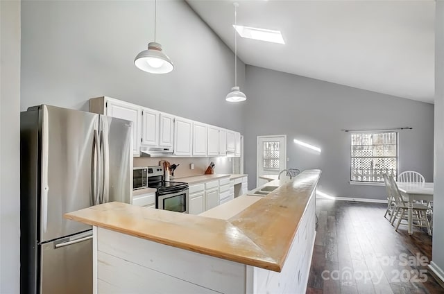 kitchen featuring a skylight, stainless steel appliances, light countertops, under cabinet range hood, and white cabinetry