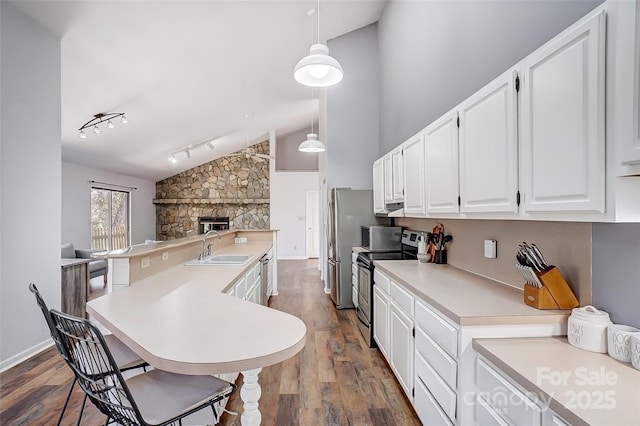 kitchen featuring dark wood finished floors, light countertops, appliances with stainless steel finishes, white cabinetry, and a sink