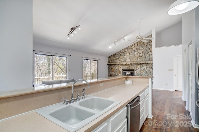 kitchen with white cabinets, lofted ceiling, open floor plan, dark wood-type flooring, and a sink