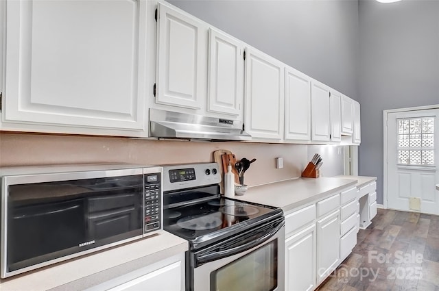 kitchen with wood finished floors, stainless steel appliances, light countertops, under cabinet range hood, and white cabinetry