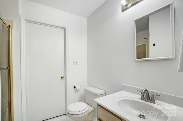 bathroom featuring a shower with shower door, a textured ceiling, toilet, and vanity