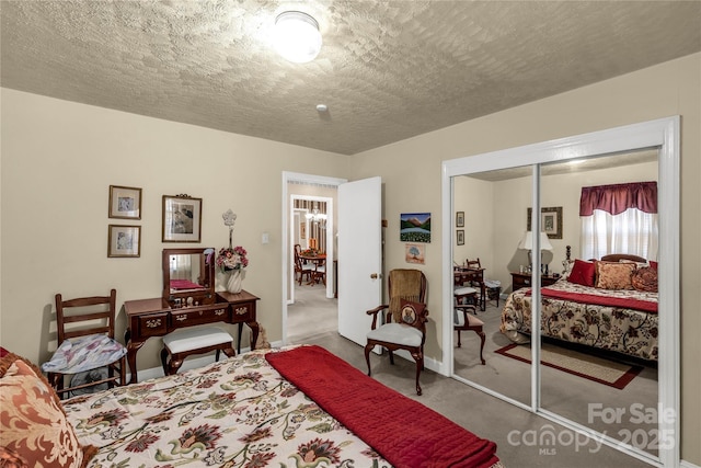 carpeted bedroom featuring a textured ceiling and a closet