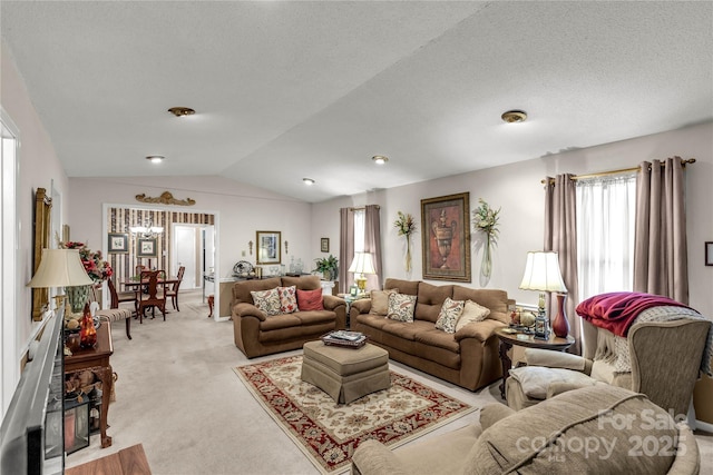 living area featuring lofted ceiling, a textured ceiling, light carpet, and a healthy amount of sunlight