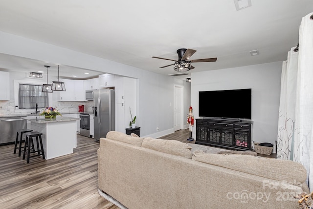 living room featuring recessed lighting, visible vents, ceiling fan, wood finished floors, and baseboards