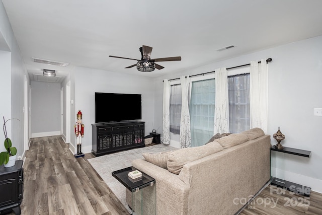 living area featuring visible vents, wood finished floors, and attic access