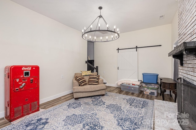 living area with stairs, a barn door, wood finished floors, and baseboards